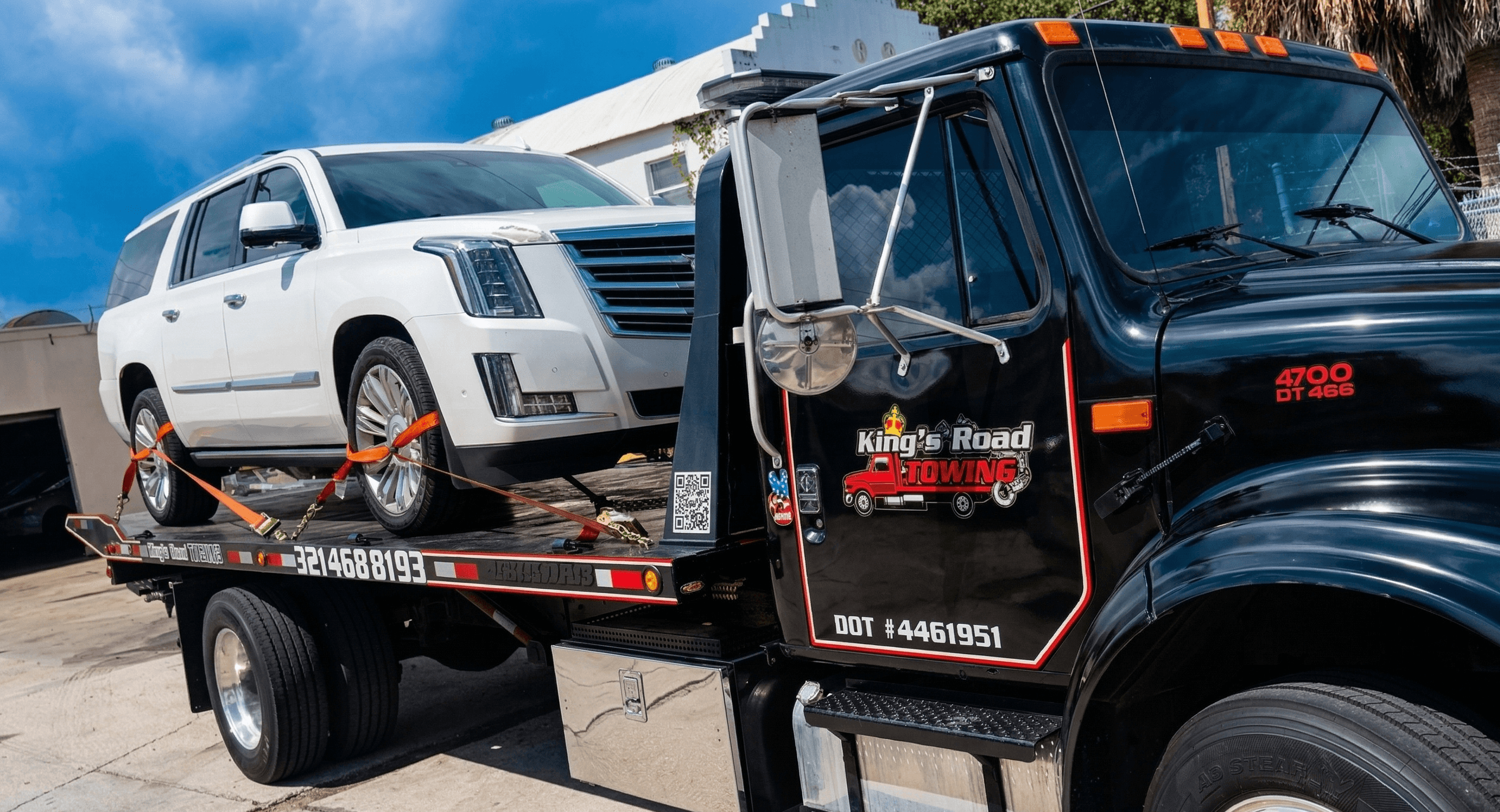 White Escalade full side view secured on flatbed
